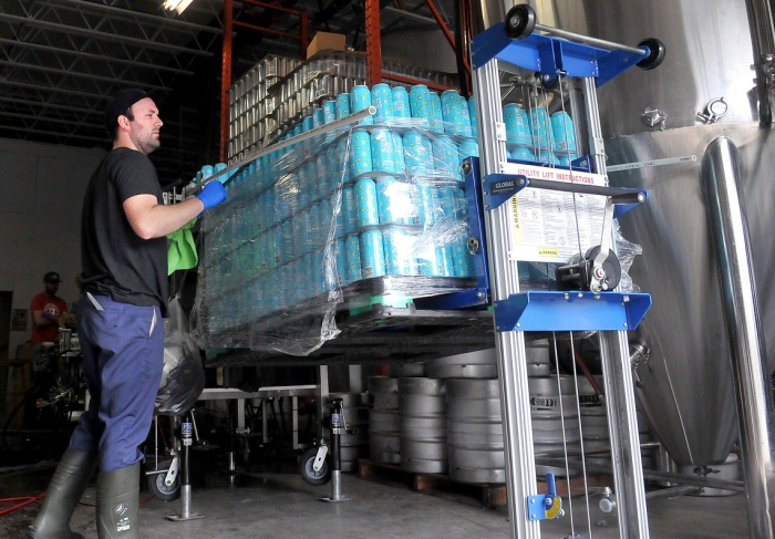 MARIO BARTEL/THE TRI-CITY NEWS Bob Maguire lines up cans for loading into the canning line.