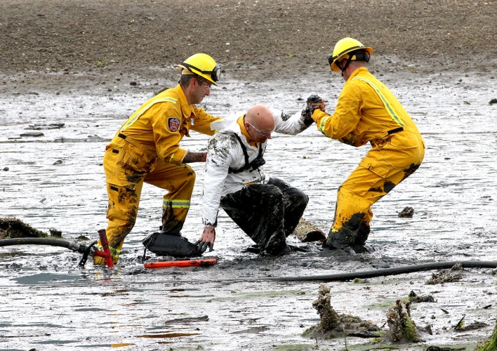 MARIO BARTEL/THE TRI-CITY NEWS Port Moody fire caption Rob Suzukovich gets some help back on his feet from his "rescuers," firefighters Darren Penner and Jason Webster, during a training exercise to extricate people trapped in the mudflats at the east end of Port Moody Inlet.