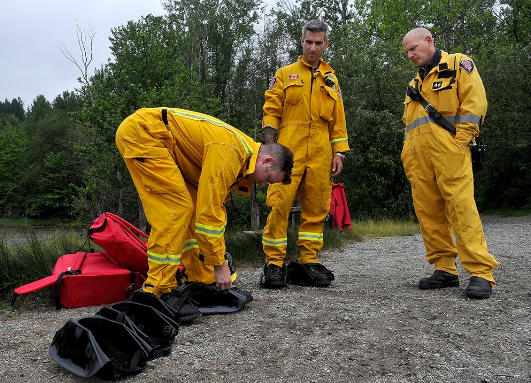 MARIO BARTEL/THE TRI-CITY NEWS Port Moody firefighters strap on special plastic overshoes that allow them to walk on the surface of the mudflats to rescue people stuck in the muck.