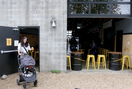 MARIO BARTEL/THE TRI-CITY NEWS Michelle Cochrane makes her arrival, with her five-month-old son, Grayson, at the monthly gathering moms and their babies at Yellow Dog Brewing in Port Moody.
