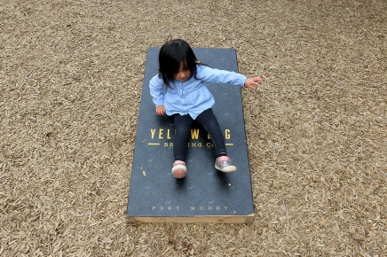 MARIO BARTEL/THE TRI-CITY NEWS Olivia Ong, 2, turns a cornhole board into an impromptu slide at the monthly gathering of the Tri-Cities Babies and Beer meetup group at Yellow Dog Brewing in Port Moody.
