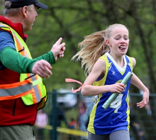 MARIO BARTEL/THE TRI-CITY NEWS Keira Cameron, from Ranch Park elementary school, is directed to victory in the Grade 4 girls race on the opening day of the 41st annual Como Lake Relays last Wednesday in Coquitlam. The Como Lake Relays is always a fun event to shoot as the kids are so determined and earnest in their efforts to do well for their school.