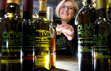MARIO BARTEL/THE TRI-CITY NEWS Daniela Hammond samples one of the 60 or so olive oils and balsamic vinegars she offers at her new olive oil dispensary in Port Moody's Newport Village. Popping light through bottles is a fun way to bring a shot to life.
