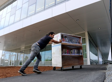 MARIO BARTEL/THE TRI-CITY NEWS Workers move the Terry Fox Library's collection of more than 260,000 items into its new home at the new Port Coquitlam Community Centre next door on Tuesday. The move took two days and, the librarian's manager, Kimberly Constable, said, everything will be in place, along with several new items and features, in time for the community centre's grand opening on Tuesday, Aug. 27, at 4 p.m. It's not often a local library moves into a new facility. And when that move is just a short walk away, the toil of that move can make an interesting photo.
